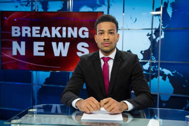 A news anchor presenting a breaking news segment