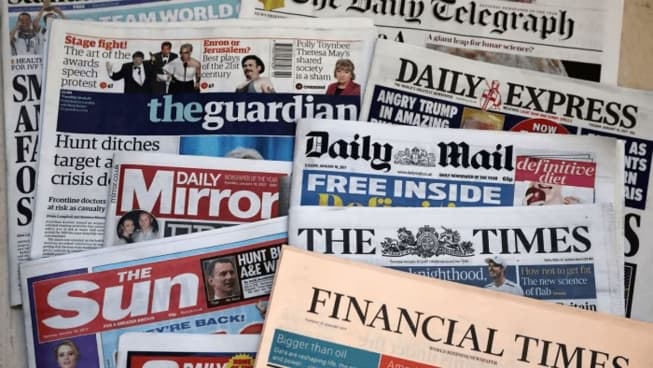 Front pages of major newspapers stacked together